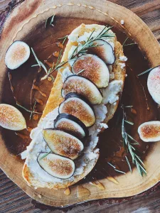 syrah-cheese-pairings sliced of bread on brown wooden round plate